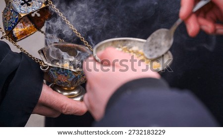Priest adding incense to censer during religious service
