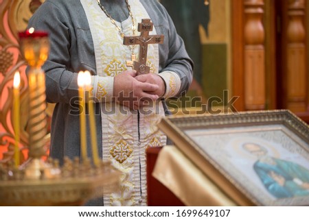 Priest with a cross on the background of the icon.