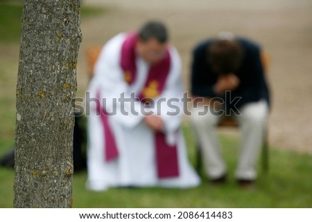 Priest giving Holy confession outside.  France. 