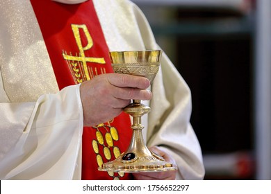 Priest holds the chalice while celebrating the mass and empty space for text