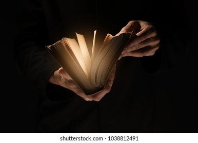 Priest with old Bible on black background, closeup - Shutterstock ID 1038812491