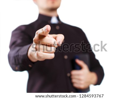 Priest pointing into the camera, isolated on white background