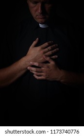 Priest Prays In A Cassock