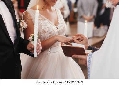 Priest Putting On Golden Wedding Ring On Bride Finger. Wedding Matrimony In Church. Exchanging Wedding Rings