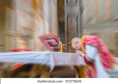 A priest saying the traditional extraordinary tridentine latin rite of the Catholic mass . Abstract artistic radial blur.