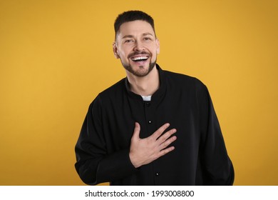 Priest Wearing Cassock With Clerical Collar On Yellow Background