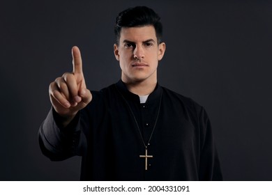 Priest Wearing Cassock With Clerical Collar On Black Background