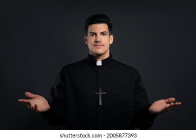 Priest Wearing Cassock With Clerical Collar On Black Background