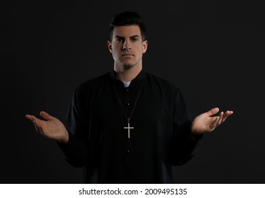 Priest Wearing Cassock With Clerical Collar On Black Background