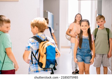 Primary Boys Classmates Making Plans In Hallway Of Private School After Class During Break.