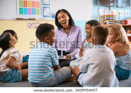 Primary Or Elementary School Class With Teacher And Model Wind Turbine Learning About Environment
