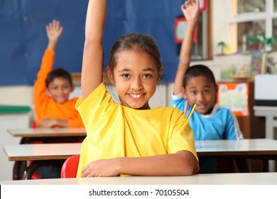 Primary school children signal with raised hands