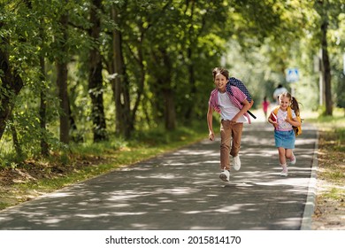 Primary School Pupil. Boy And Girl With Backpacks Walking Down Street. Happy Children Happy To Go Back To School. Beginning School Year. Kids Are Happy To Run To School. Education.