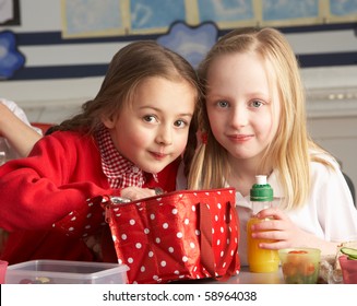 Primary School Pupils Enjoying Packed Lunch In Classroom