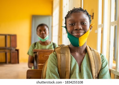 primary school pupil's sitting in class, wearing face masks, and observing physical distancing