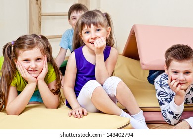 Primary School Students Sitting On Tumbling Mats