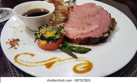 Prime Rib With Potatoes And Asparagus On White Dinner Plate