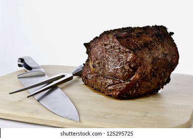 Prime Rib Roast sitting on a cutting board with a chef knife and carving fork - Powered by Shutterstock