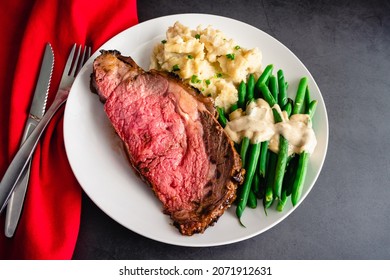 Prime Rib Served With Garlic Mashed Potatoes And Green Beans: Medium-rare Prime Rib Dinner Served With Side Dishes On A White Plate