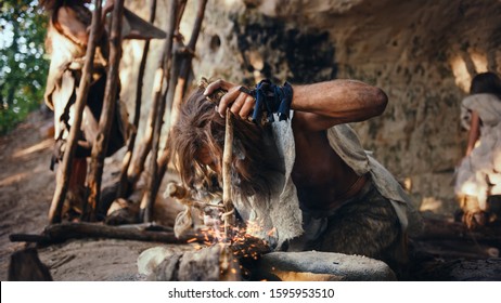 Primeval Caveman Wearing Animal Skin Trying to make a Fire with Bow Drill Method. Neanderthal Kindle First Man-Made fire in the Human Civilization History. Making Fire for Cooking.