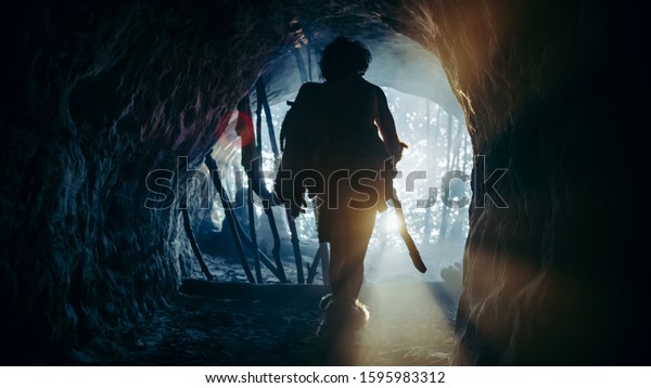 Primeval Caveman Wearing Animal Skin and Fur\
Holds Stone Tipped Spear Comes out of His Cave into Prehistoric\
Forest Ready to Hunt. Neanderthal Going Hunting into the Jungle.\
Shot with Cold Filter.