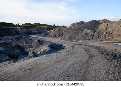 Primitive road for quarry trucks through quarrying territory. Sunny summer view.