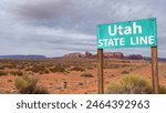 Primitive Wooden Utah State Line Sign on the edge of Monument Valley Navajo National Land with beautiful sandstone buttes and panoramic landscape in the background - Utah, USA