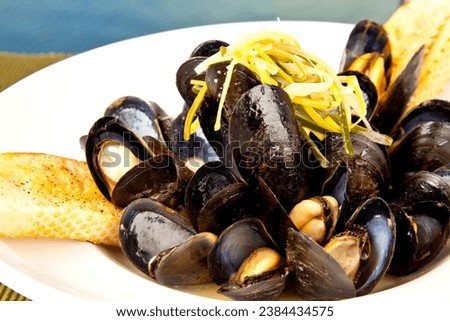 Prince Edward Island mussels in a broth with bread at a restaurant.