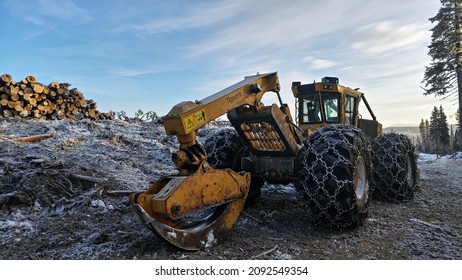 Prince George, British Columbia, Canada - February 15, 2021: Active logging operations showing parked skidders along the roadside.