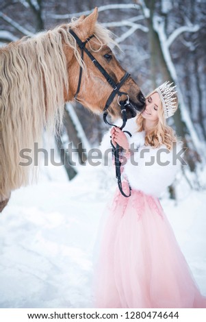 Princess in crown with horse in winter. Fairy tale