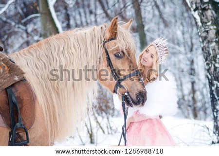 Princess in crown with horse in winter. Fairy tale	