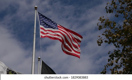 Princeton, New Jersey, USA, Oct. 7, 2020: US Flag fluttering in the wind against a blue sky with fluffy white clouds
