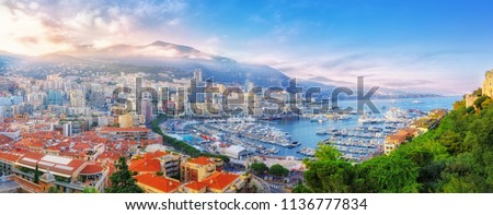 Principality of Monaco. Beautiful panoramic view on Monaco, golden hour scenery. View on apartment building, casino, great port with luxury yachts. Monaco is popular travel destination, wealth symbol.
