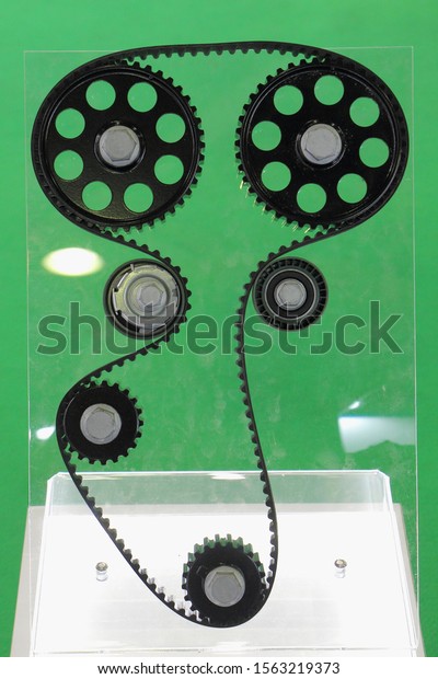 Principle of operation dual overhead camshaft\
drive model, two cog wheel, tensioner pulley and bypass roller with\
timing belt on green\
background