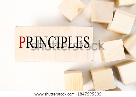 principles, text on a block of wood against a light background