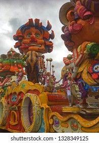 Prinsenbeek/ The Netherlands - 03-03-2019: Carnival Parade In The Rain With Huge Wagon With Figures Of Paper Mache With Giant Heads And People Dressed As Clowns Having Fun, 