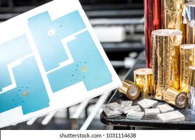 Print sample with foil rolls and cliche for stamping on the press machine at the printing manufacturing - Shutterstock ID 1031114638