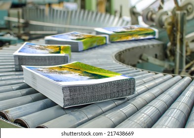 Print shop (press printing) - Finishing line. Post press finishing line machine: cutting, trimming, paperback and binding - Shutterstock ID 217438669
