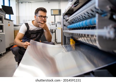 Print Worker Trying To Fix The Problem On Computer To Plate Machine In Printing Shop.