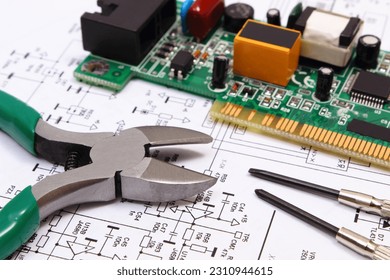Printed circuit board with electrical components and precision tools lying on construction drawing of electronics, drawings and tools for engineer jobs, technology