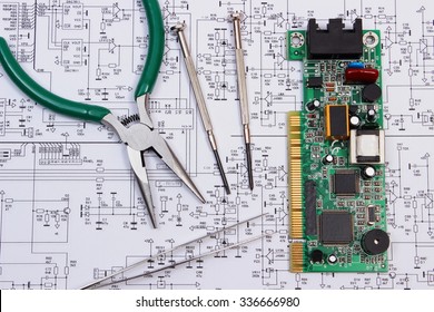 Printed circuit board with electrical components and precision tools lying on construction drawing of electronics, drawings and precision tools for engineer jobs, technology