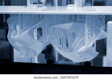 Printed models on 3D printer close-up. Objects printed on photopolymer sla 3D printer from liquid photopolymer resins on printing platform. Modern progressive additive technology. 3D printer printing