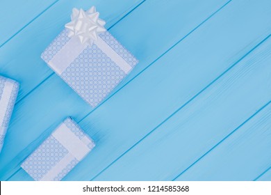Printed pattern gift boxes. Copyspace. Blue wood background.