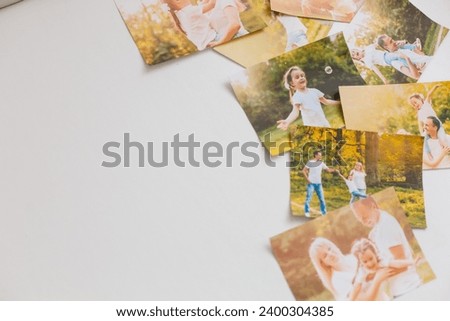 printed photos of family summer vacation lying on desk.