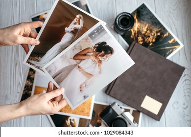 Printed Wedding Photos With The Bride And Groom, A Vintage Black Camera, Photoalbum And Woman Hands With Two Photos