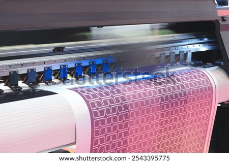 A printer is printing a colorful design on a piece of paper. The design features a series of squares and circles, with some of the squares being larger than the others