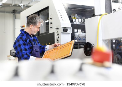 Printing House, Bookbinding. A Printer With A Punch At The Machine.