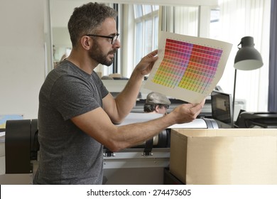 Printing industry: Graphic designer checks the color with color swatch. - Powered by Shutterstock