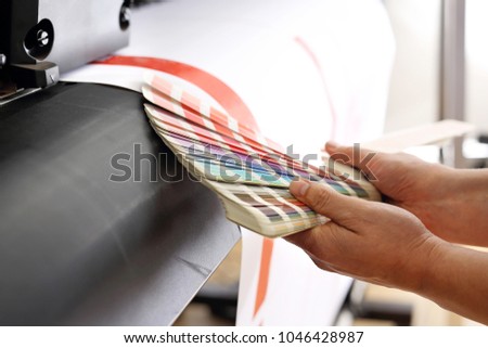 Printing machine, color print. The printer checks the color of the printout on the color sampler.