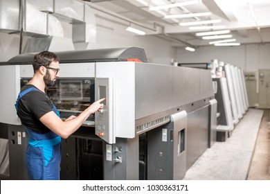 Printing operator working with offset machine at the printing manufacturing